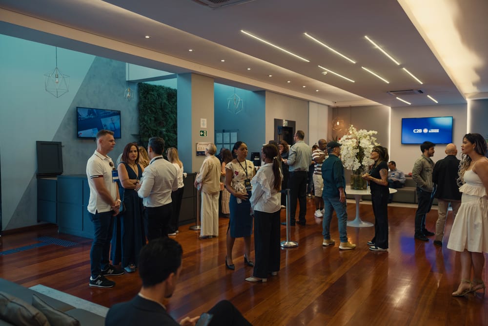 Salão do evento cheio, pessoas recebidas com atenção